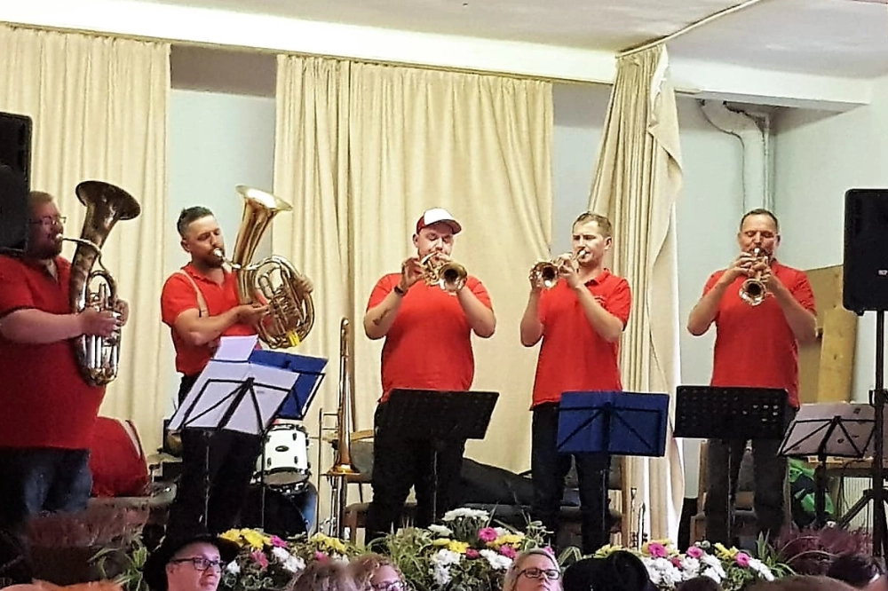 Bühnenauftritt in roten Shirts. Kapelle für Kirmes spielt mit Trompeten und Bläsern – Blasmusik Thüringen live.
