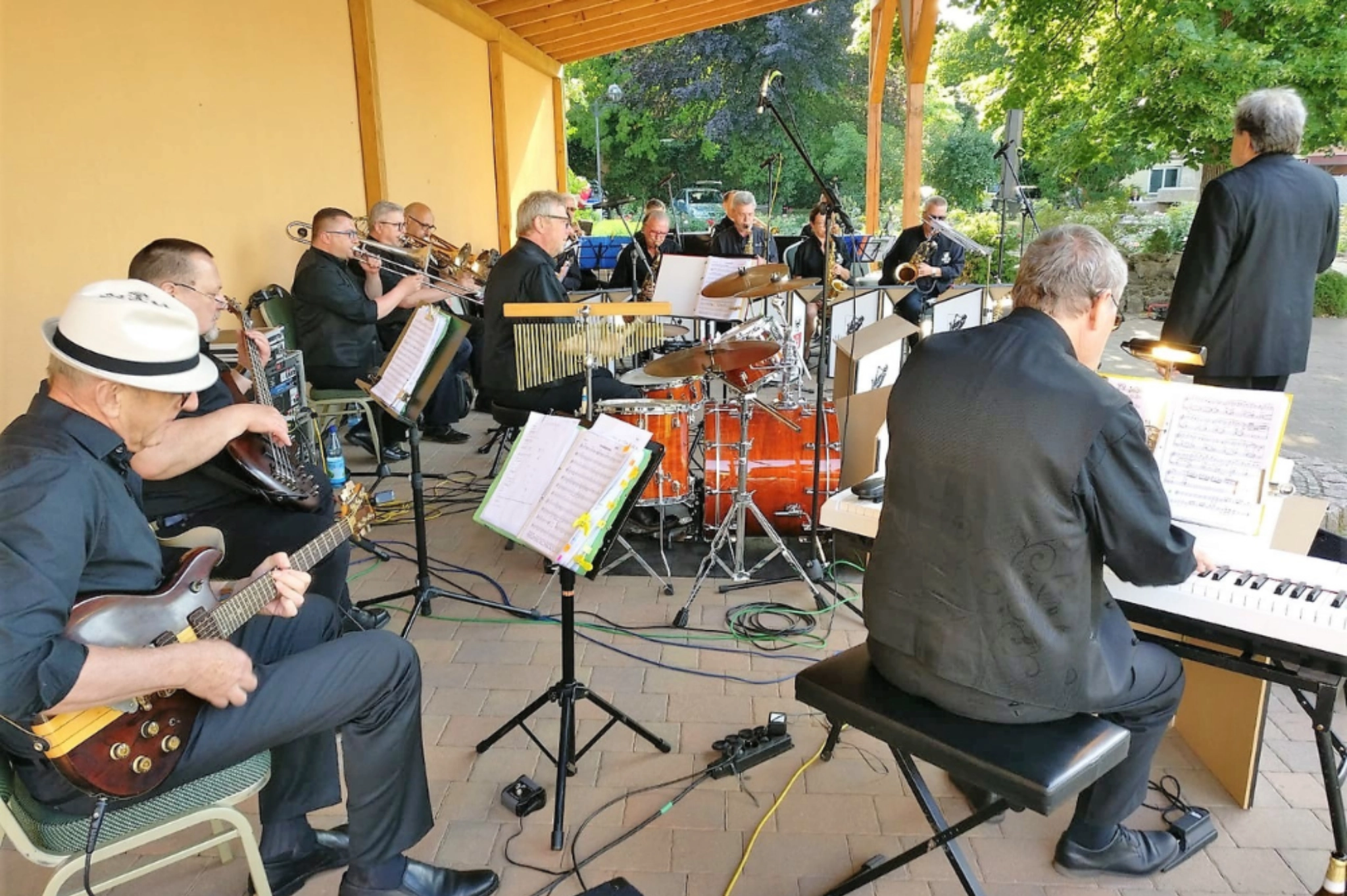 Open-Air Orchester Thüringen. Blaskapelle mit Schlagzeug, Keyboard und Bläsern bei einem Sommerauftritt.
