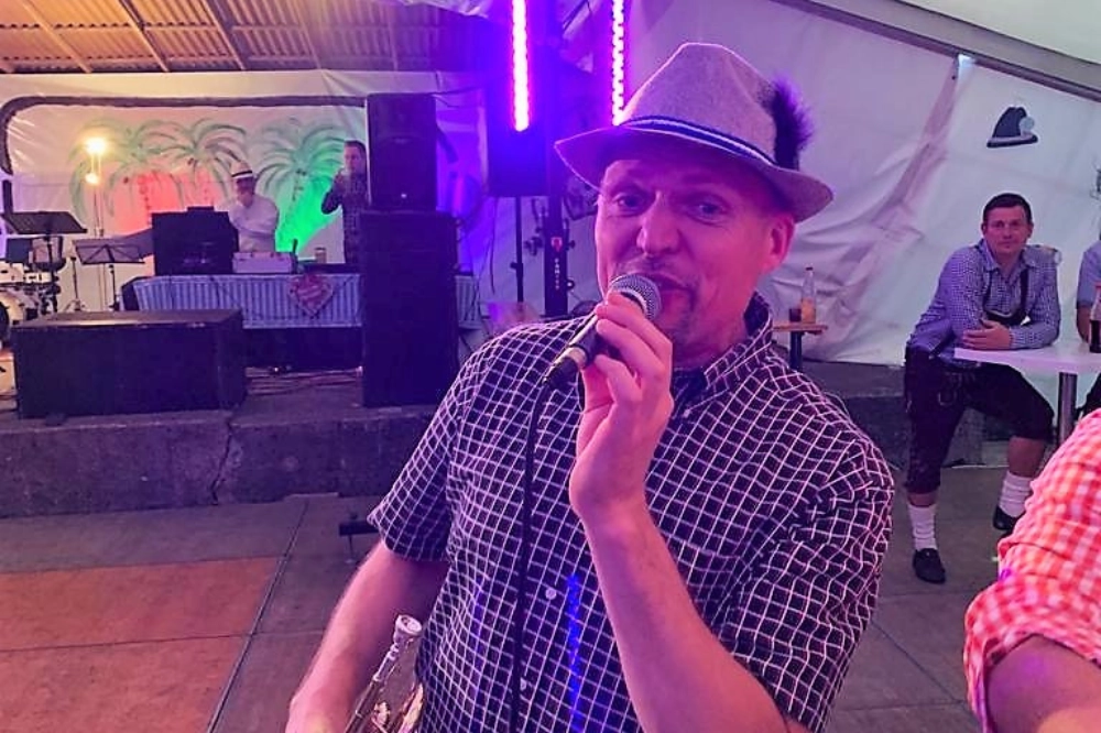 Sänger im Festzelt Thüringen. Live-Moderation oder Gesang mit Mikrofon – Blasmusik-Event und Kirmes-Stimmung.